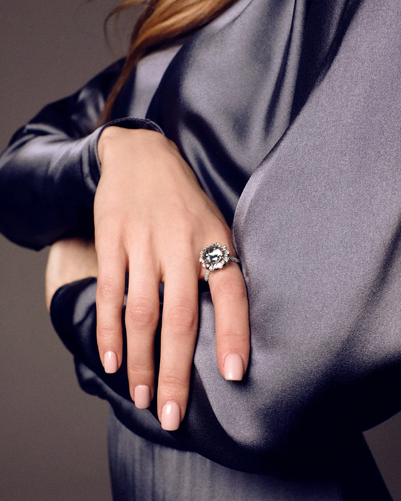 Salema white gold ring by ValeOro with a light-blue aquamarine in a diamond halo, worn on the hand