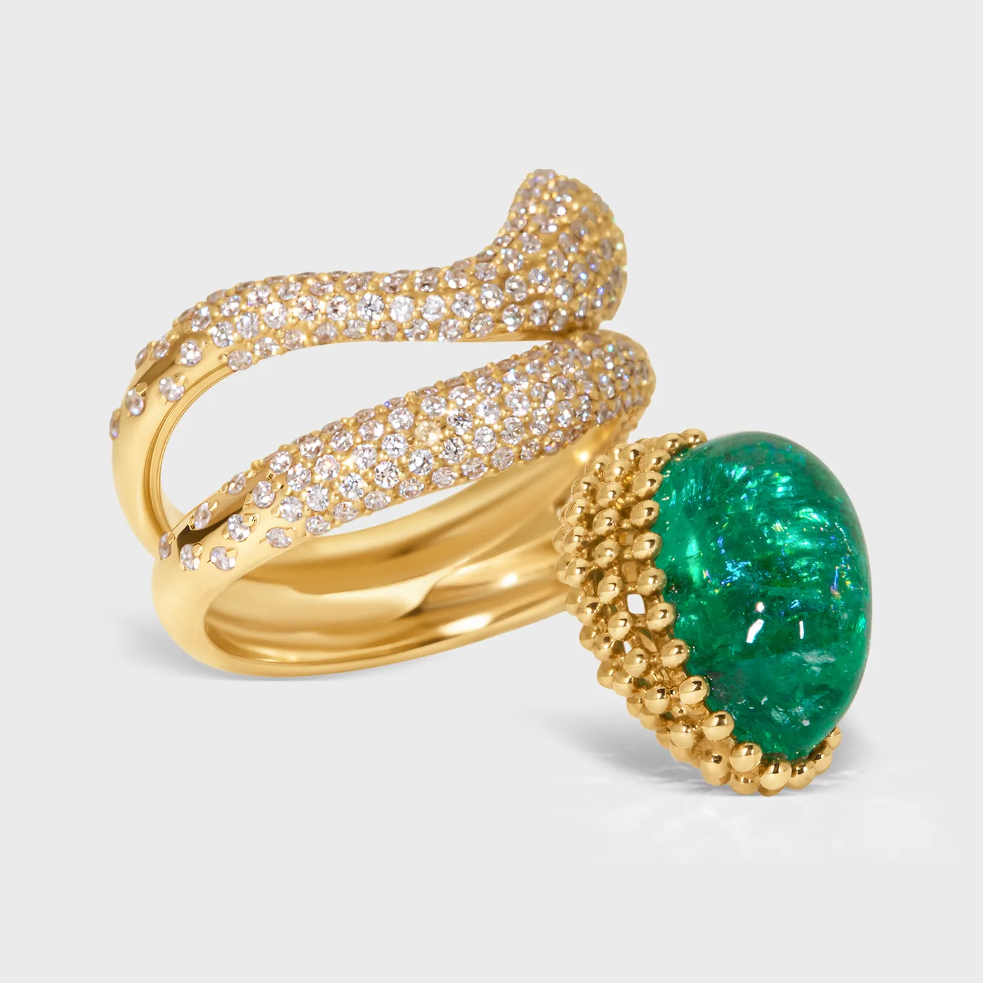 Le Mans yellow gold ring by ValeOro with a green emerald cabochon framed by gold beads, close-up
