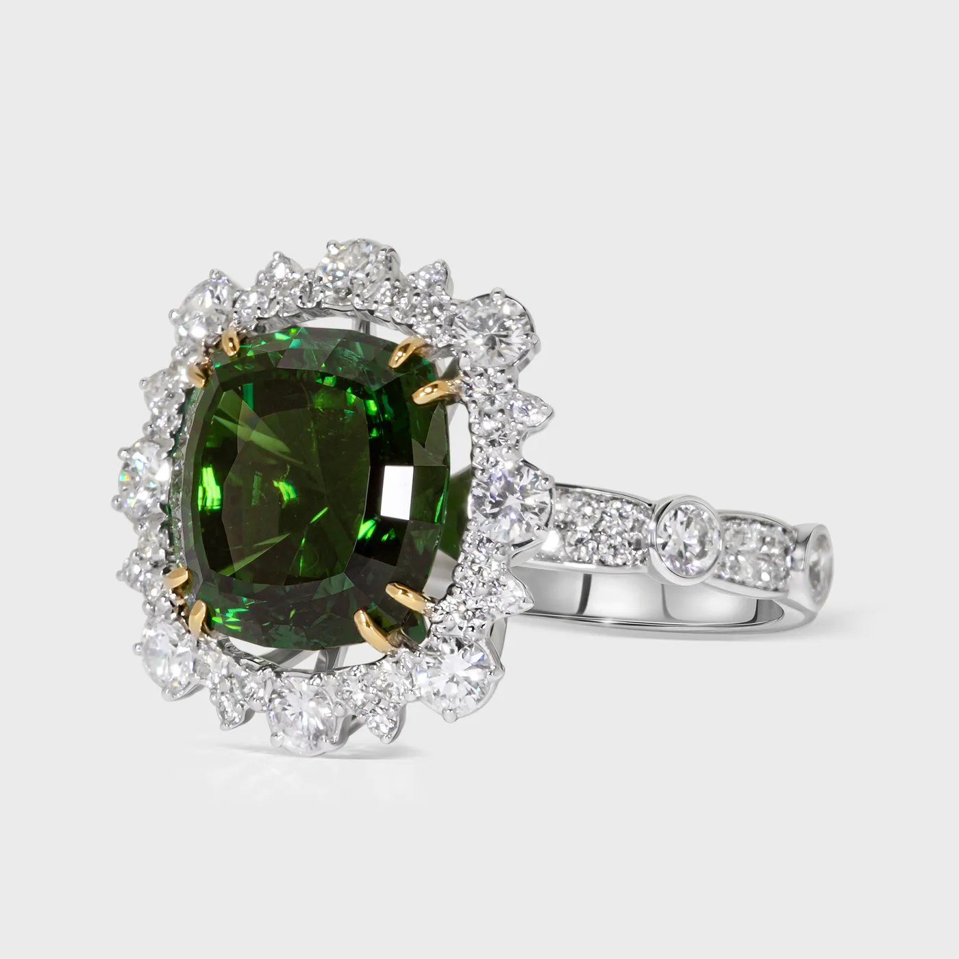 Benissa white gold ring by ValeOro with a green tourmaline in yellow gold prongs and a diamond-set band, three-quarter view
