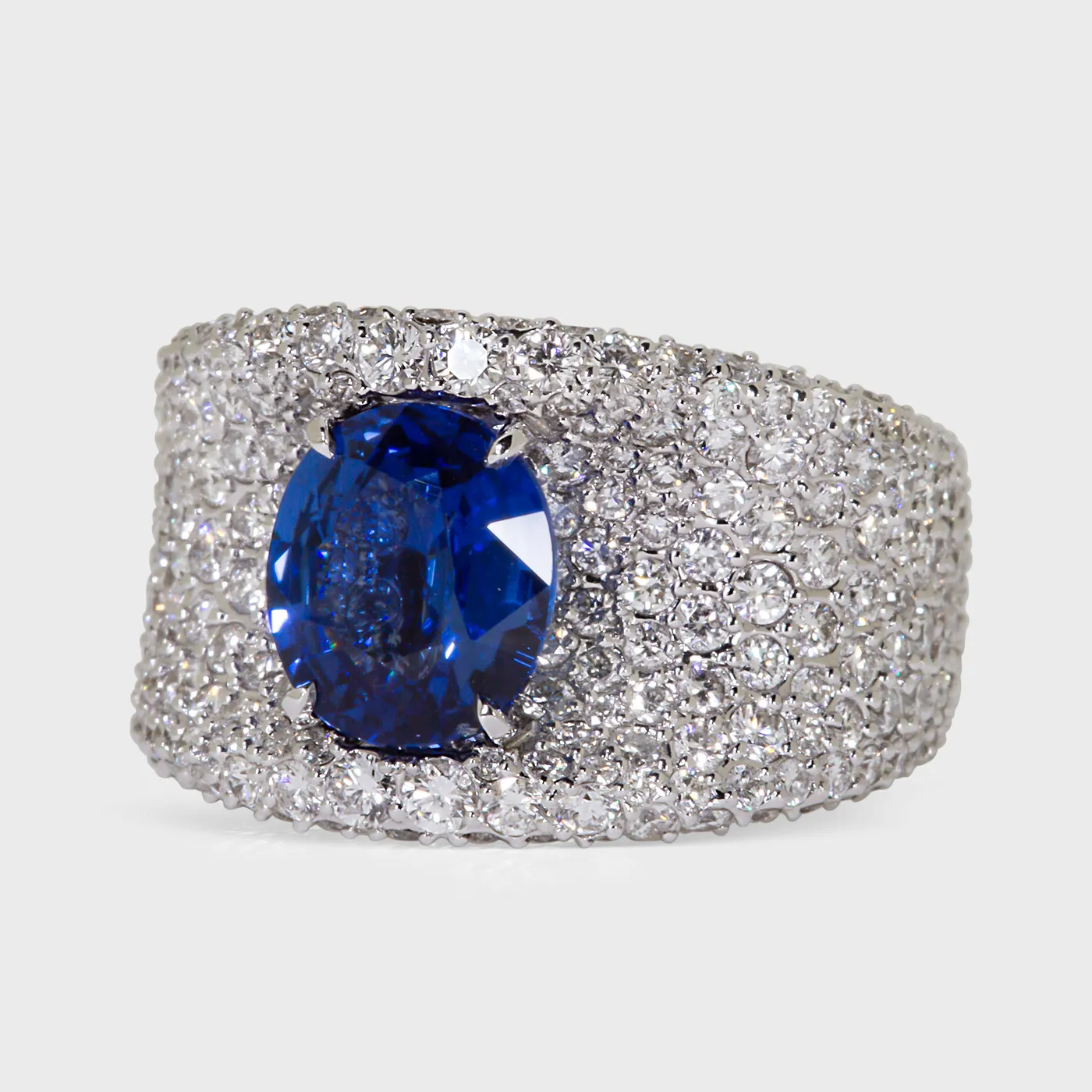 La Massana white gold ring by ValeOro with an oval blue sapphire framed by pavé diamonds, three-quarter view