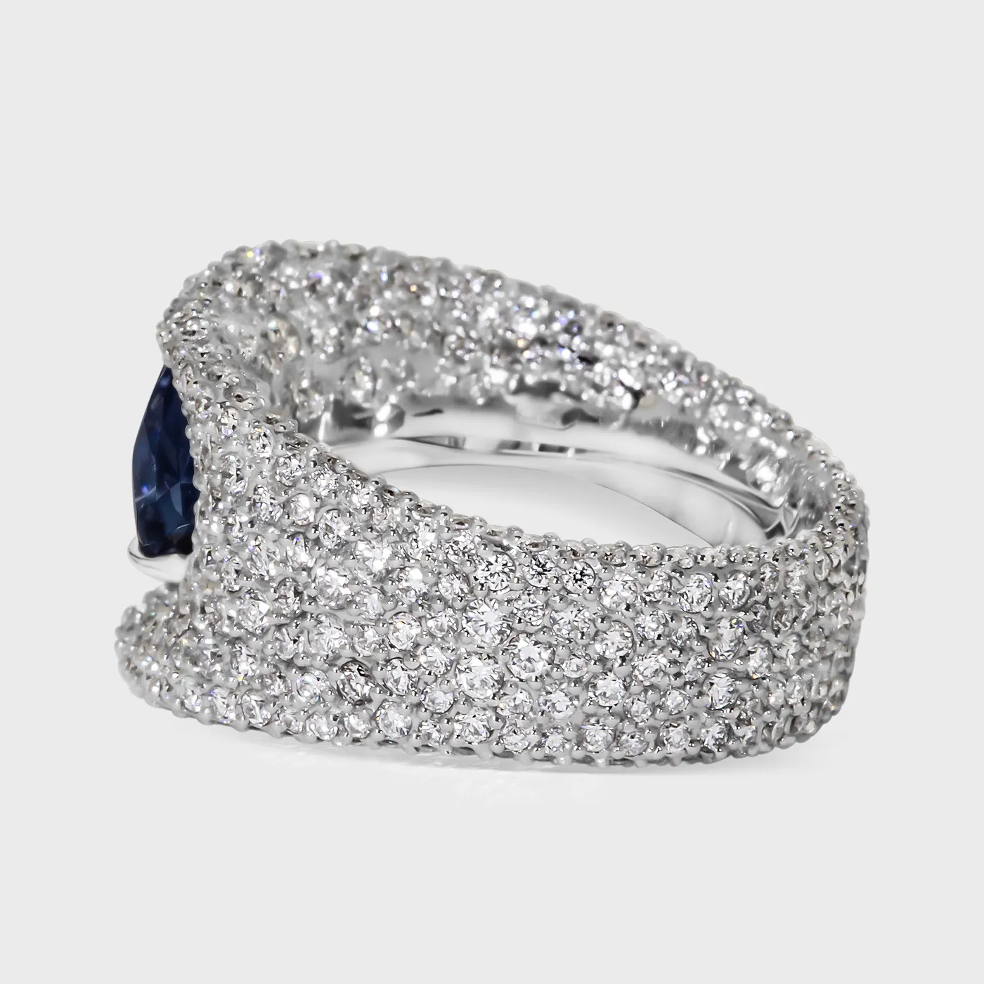 La Massana white gold ring by ValeOro with a wide pavé diamond band and a blue sapphire, side view
