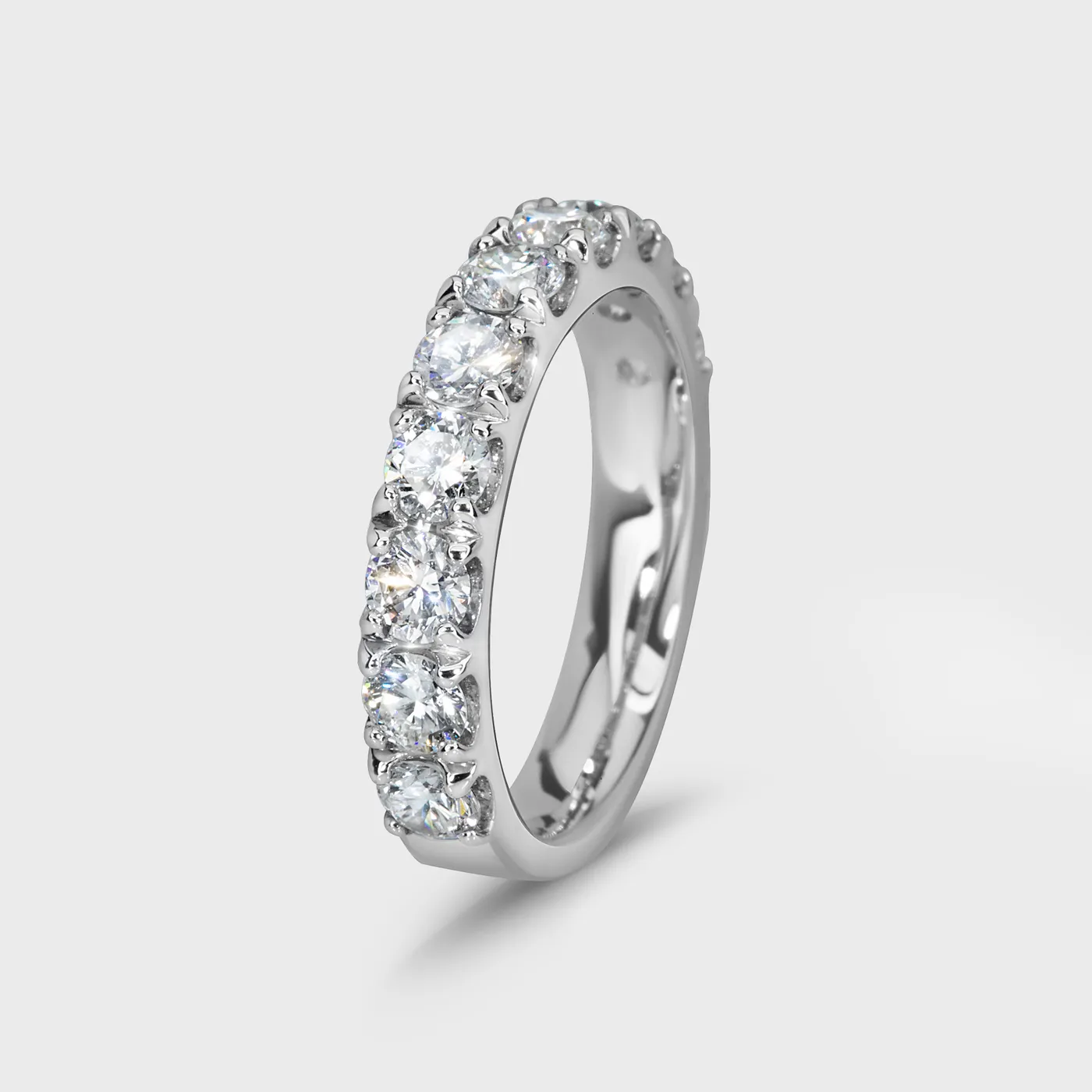 Gloss white gold ring by ValeOro with prong-set round diamonds along the band, three-quarter view
