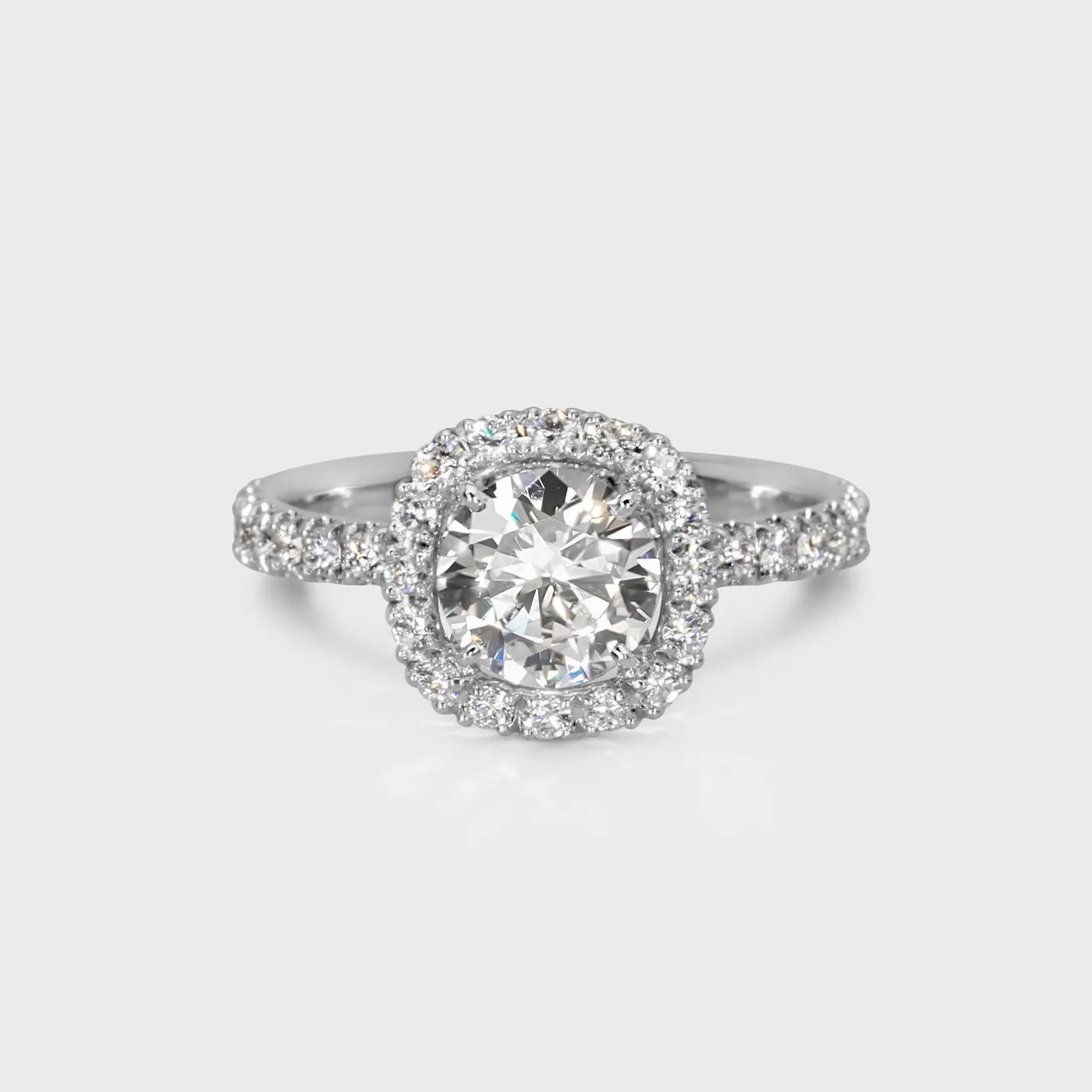 Radiance white gold ring by ValeOro with a round central diamond in a diamond halo and a pavé-set band, front view