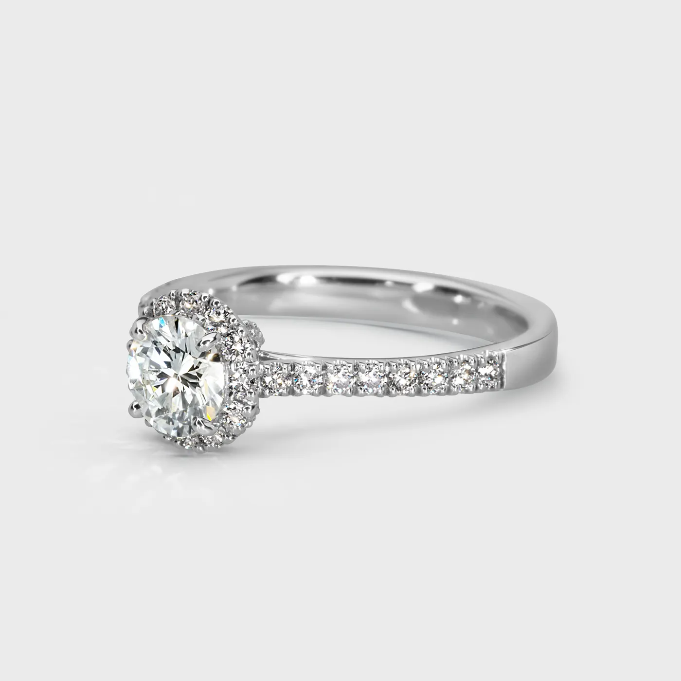 Aurora white gold ring by ValeOro with a round halo diamond and a pavé-set band, three-quarter view