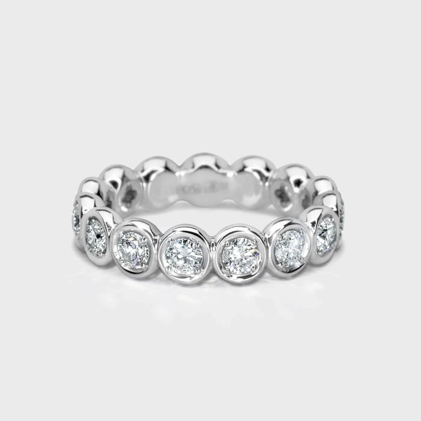 Clover white gold ring by ValeOro with a row of round bezel-set diamonds, front view