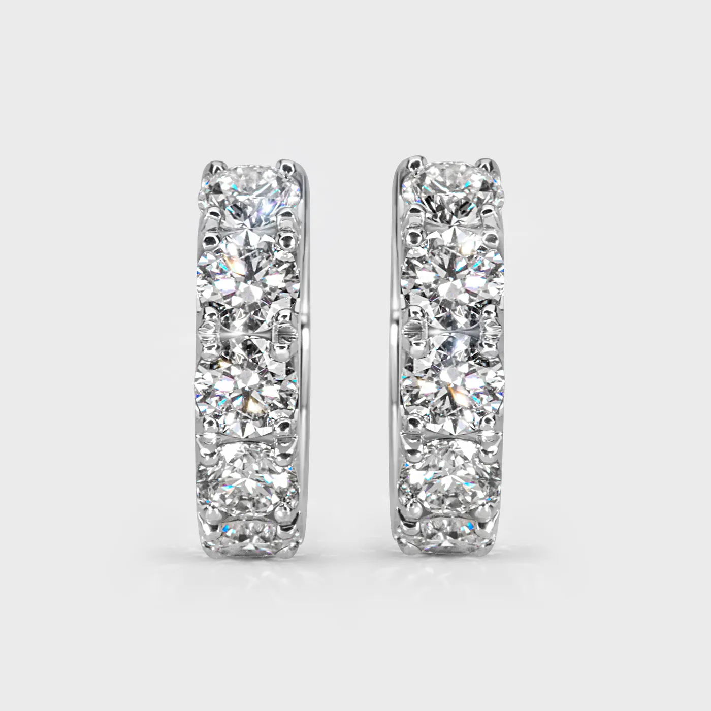 Gloss white gold hoop earrings by ValeOro with a line of large round diamonds, front view