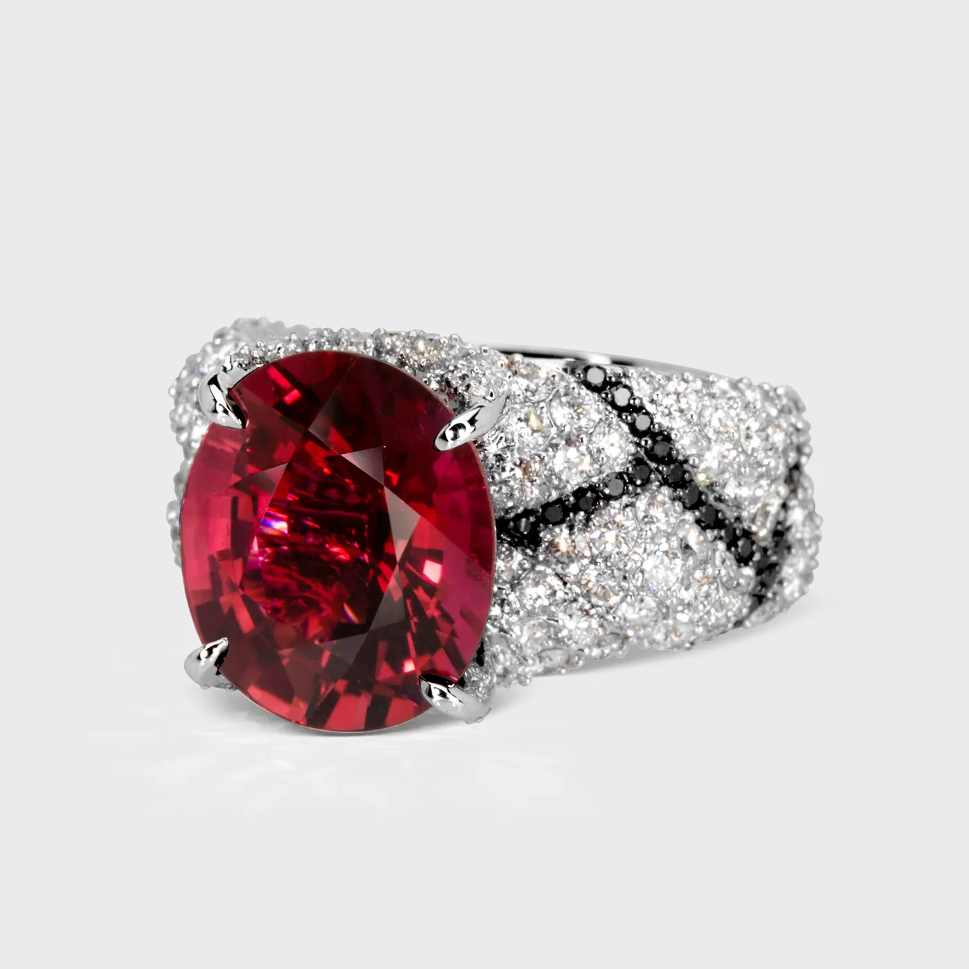 Oase white gold ring by ValeOro with a red tourmaline and diagonal lines of black diamonds, three-quarter view