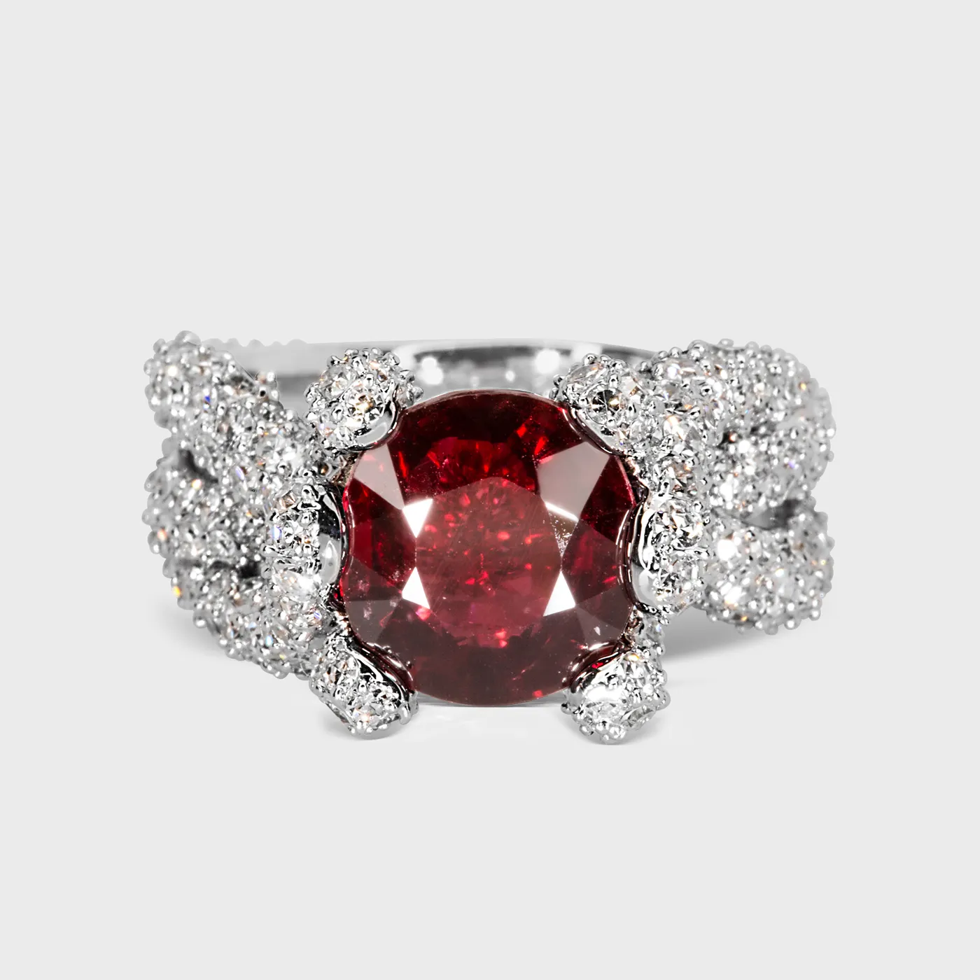 Caledon white gold ring by ValeOro with a round red spinel in a woven pavé diamond band, front view