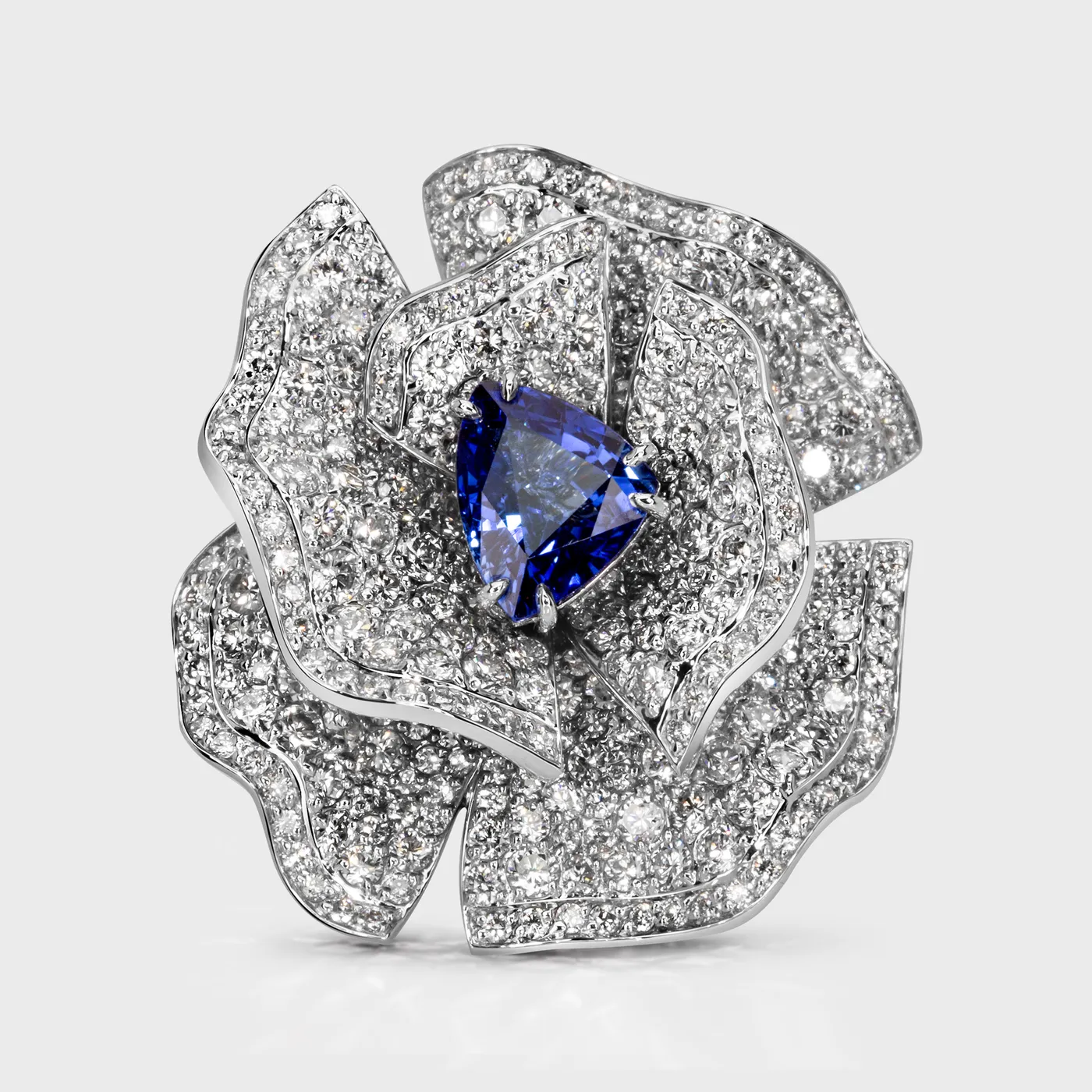 Cornflower white gold ring by ValeOro with a triangular blue sapphire framed by diamond petals, front view