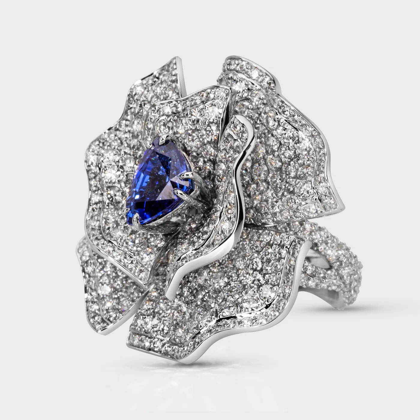 Cornflower white gold ring by ValeOro with a blue sapphire in a diamond flower design, three-quarter view