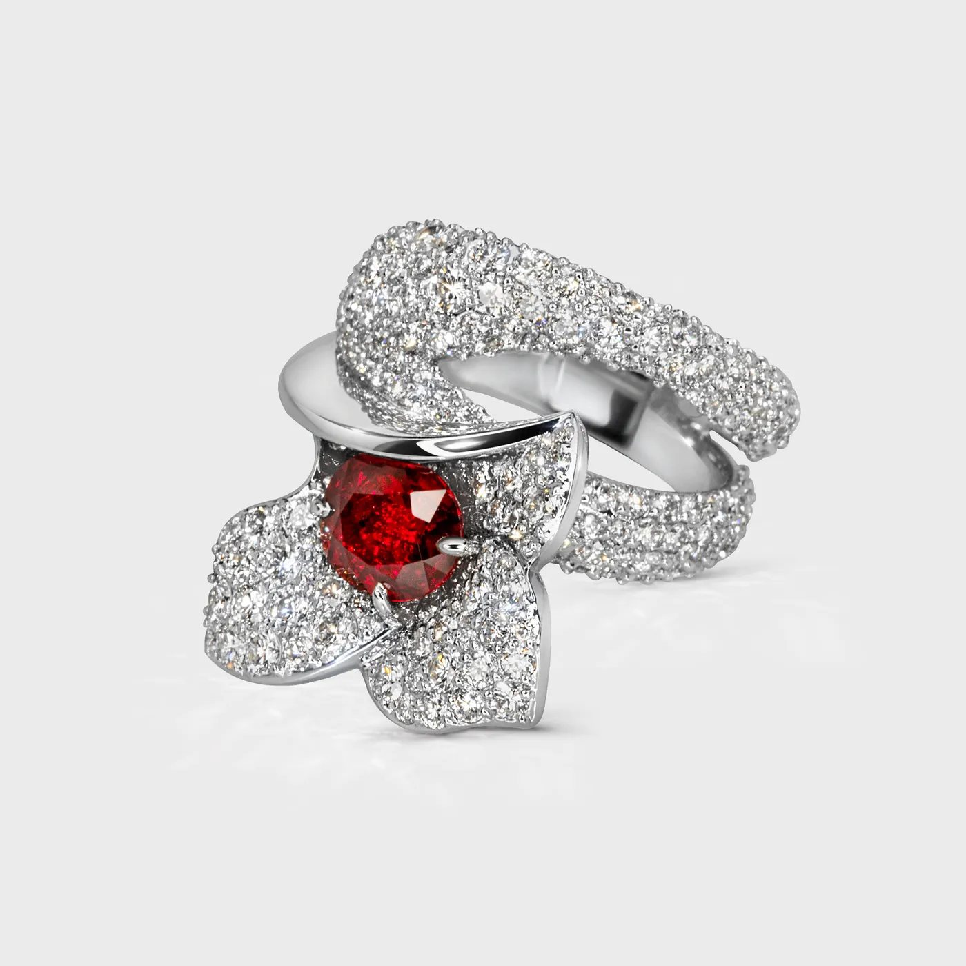 Lily white gold ring by ValeOro with a red sapphire in a diamond flower and pavé band, three-quarter view