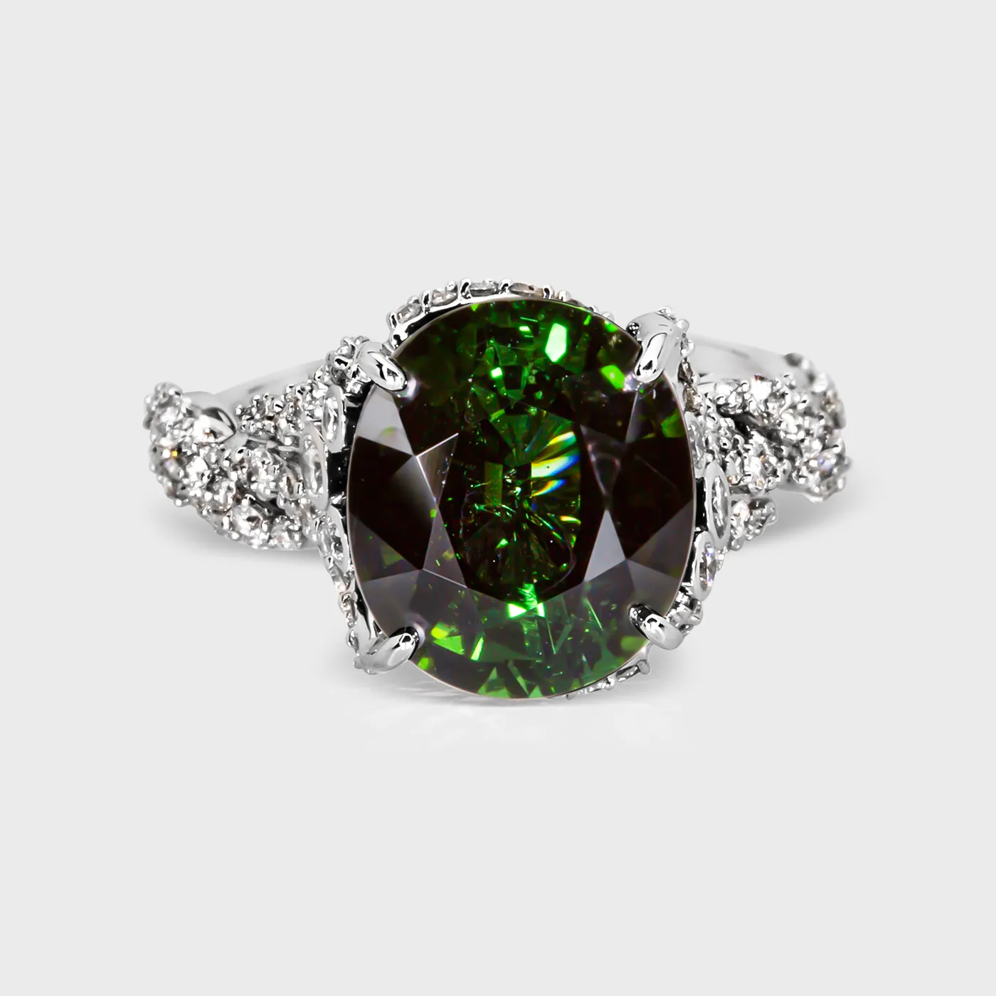 Glorioza white gold ring by ValeOro with an oval green tourmaline framed by diamond-set vine shoulders, front view