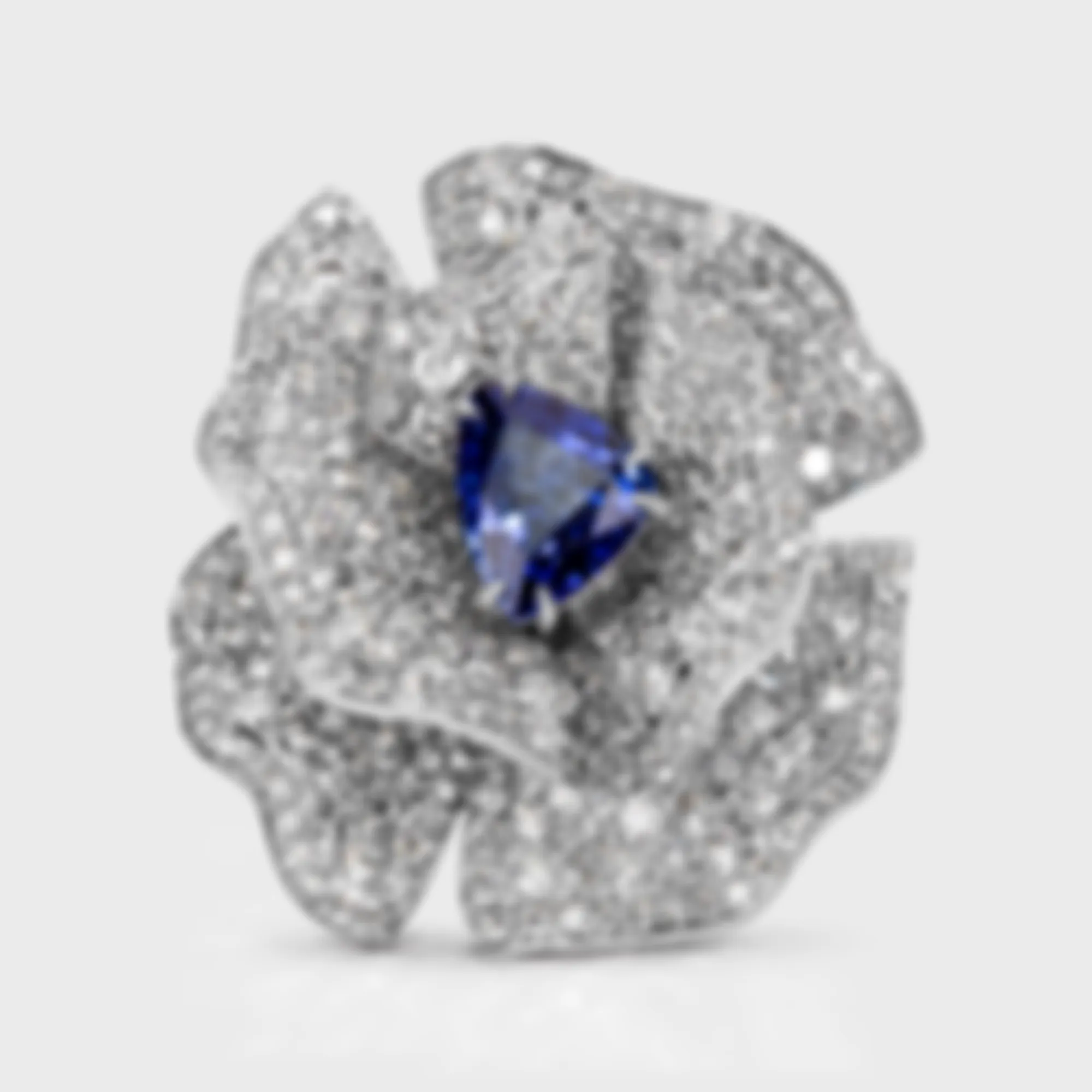 Cornflower white gold ring by ValeOro with a triangular blue sapphire framed by diamond petals, front view