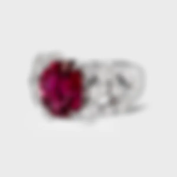 Ceres white gold ring by ValeOro with an oval red tourmaline and scattered bezel-set diamonds, three-quarter view