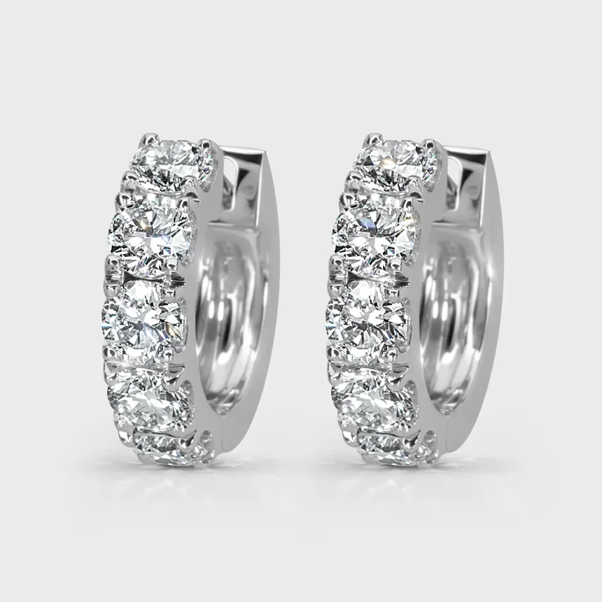 Gloss white gold hoop earrings by ValeOro set with round diamonds along the front, three-quarter view