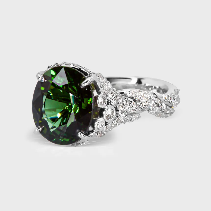 Glorioza white gold ring by ValeOro with a green tourmaline above a twisting diamond vine band, three-quarter view