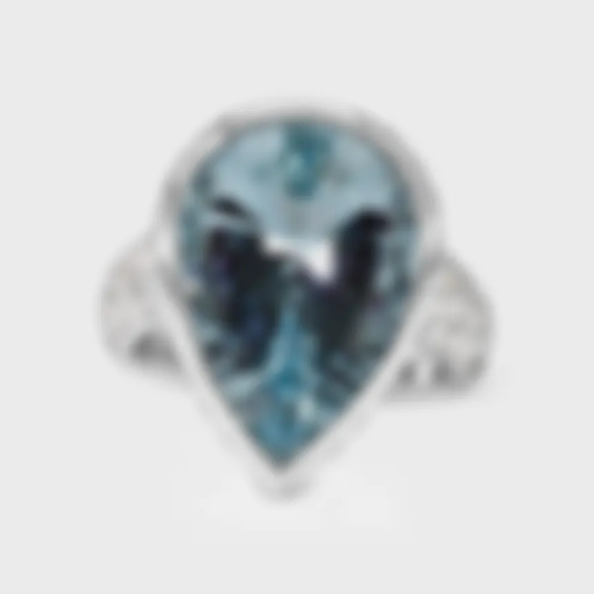 Donostia white gold ring by ValeOro with a pear-shaped blue aquamarine in a bezel and pavé diamond band, front view
