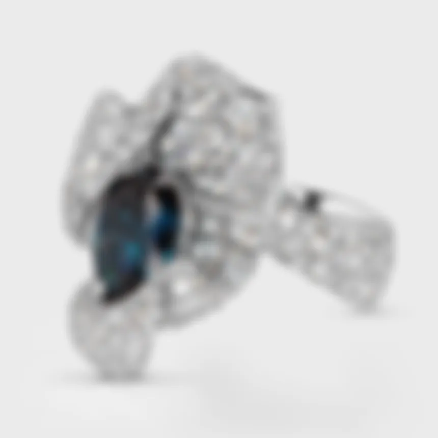 Azure white gold ring by ValeOro with a blue spinel and a diamond-set band in an undulating design, side view