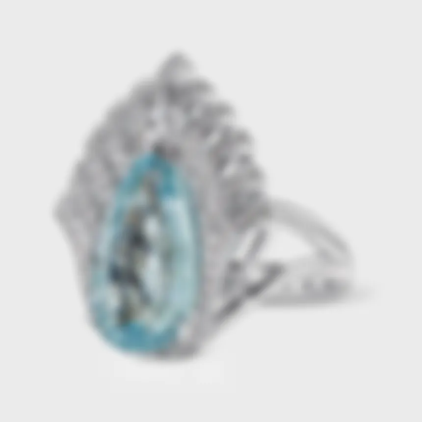 Living white gold ring by ValeOro with a pear-cut aquamarine and openwork diamond rays above the stone, three-quarter view