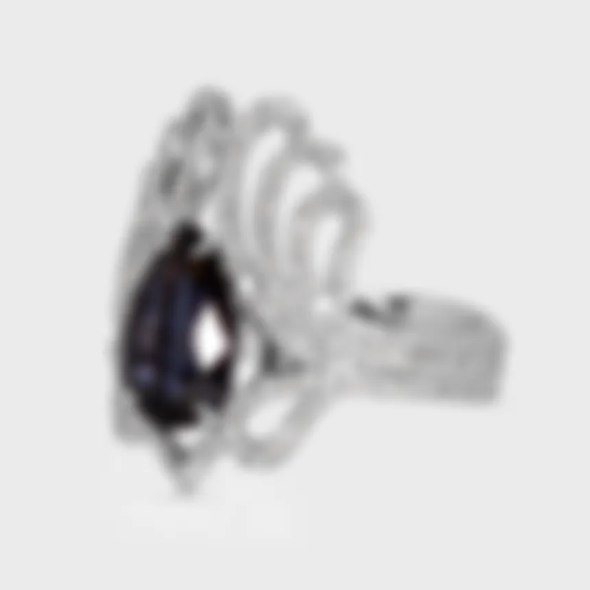 Regalia white gold ring by ValeOro with a pear-cut blue spinel and curling diamond scrollwork, side view