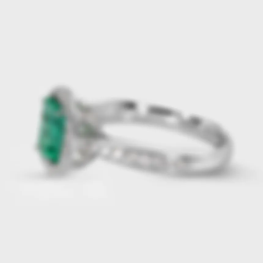 Ural white gold ring by ValeOro with a green emerald and diamond halo on a pavé-set band, three-quarter view